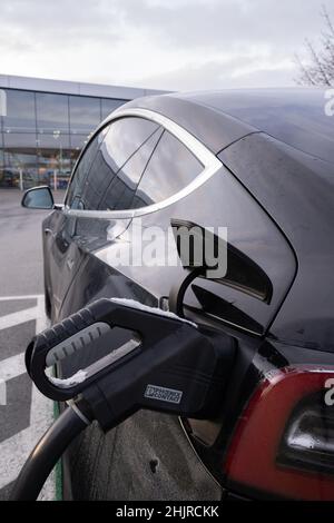 Sankt Polten, Österreich - 8. Januar 2022. Eine statische Aufnahme eines soliden schwarzen Tesla Model 3 Doppelmotors, der an der LIDL DC-Ladestation für den Supermarkt geladen wurde Stockfoto