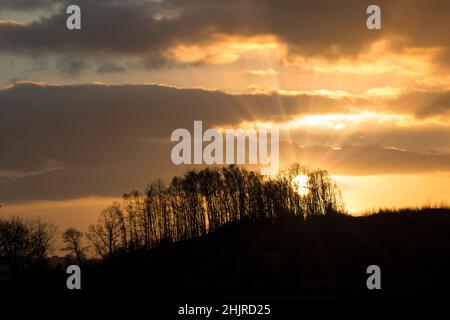 Landschaft mit dramatisch untergehenden Sonne, die einen Sonnenburst-Effekt erzeugt. Stockfoto