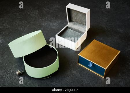 3 wunderschöne leere Schmuckkisten auf dunkelgrauem Hintergrund Stockfoto
