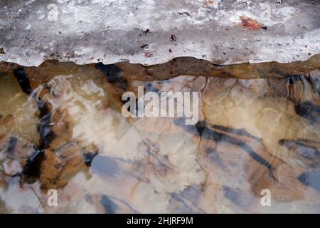 Eingetauchte Eis- und Sandmuster in eisigen Flüssen in Nahaufnahme Stockfoto