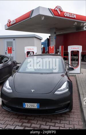 Wichrow, Polen - 14. Januar 2022. Eine statische Aufnahme eines soliden schwarzen Tesla Model 3 Zweimotor-allradantriebs mit langer Reichweite, der im Winter am Kompressor aufgeladen wird Stockfoto