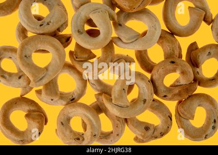 Taralli tarallini oder tarallucci mit Fenchelsamen aus Apulien, Italien, isoliert auf gelbem Hintergrund in der Draufsicht Stockfoto