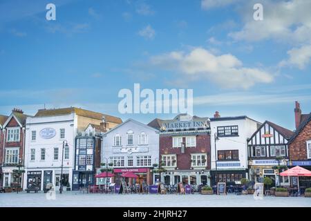 Salisbury England mittelalterlicher Marktplatz im Stadtzentrum mit einer langen Reihe von Geschäften, Bars, Cafés und Restaurants unter einem blau-weißen Wolkenhimmel Stockfoto
