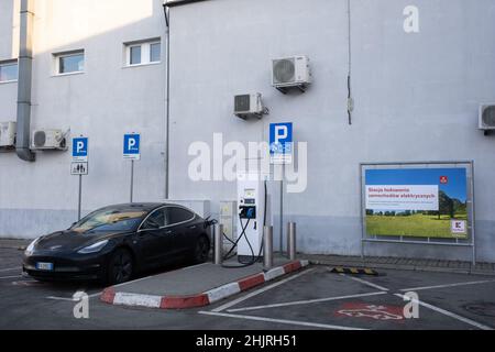 Breslau, Polen - 16. Januar 2022. Eine statische Aufnahme eines soliden schwarzen Tesla Model 3 Dual-Motors, der an der Kaufland Supermarkt DC Ladestation i geladen wurde Stockfoto