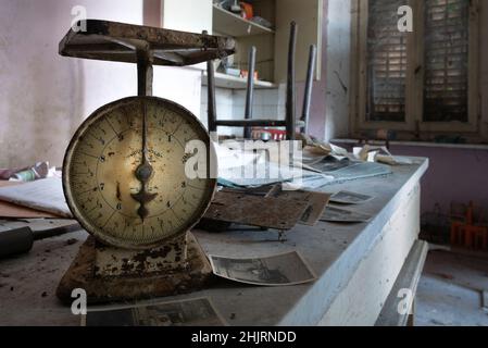 Dieses Zimmer ist eine alte Küche, mit Tischen, Kühlschrank, Töpfen, Herd und Möbeln, Einer verlassenen Villa in der italienischen Landschaft. Urbex Stockfoto