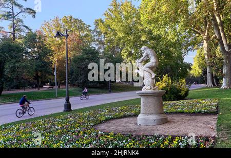 Radfahrer kommen an der Fernan Nunez Promenade am Herkules und der nemean Lion Skulptur vorbei. Retiro Park, Madrid, Spanien. Stockfoto