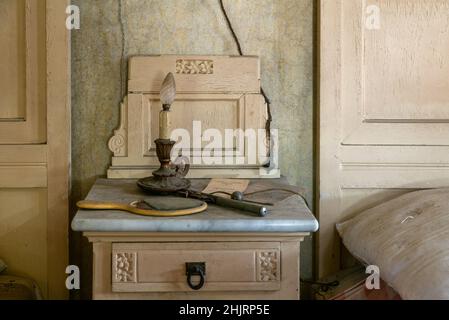 Italien, Den 20. Januar 2021. Fast verbrannte Kerze auf einem Nachttisch im Schlafzimmer, in einem verlassenen Haus. Urbex Stockfoto