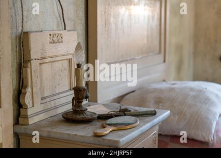 Italien, Den 20. Januar 2021. Fast verbrannte Kerze auf einem Nachttisch im Schlafzimmer, in einem verlassenen Haus. Urbex Stockfoto