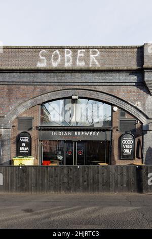 Birmingham, West Midlands, Großbritannien, Januar 28th 2022: Der Pub der Indian Brewery, der sich im Bogen eines Eisenbahnviadukts befindet, hat "nüchterne" Graffiti darüber gesprüht. Stockfoto