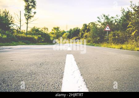 Leere gerade Straße in der Mitte des Waldes in der kroatischen Landschaft. Asphaltgrund mit weißen Linien zur Mitte. Bäume und Naturlandschaft Stockfoto