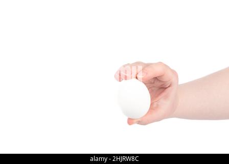 Der Mensch hält mit den Fingern ein weißes Hühnereier. Speicherplatz kopieren. Stockfoto