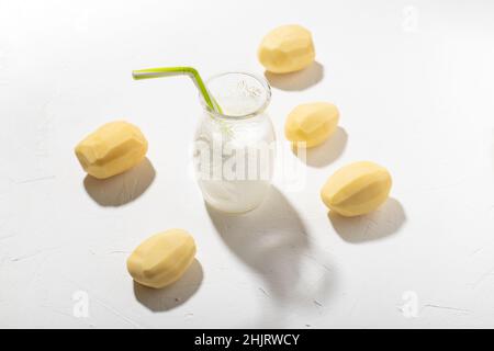 Kartoffelmilch-Konzept. Flasche mit Kartoffelmilch auf weißem Hintergrund. Eine Alternative zu tierischen Produkten. Vegane Küche. Stockfoto