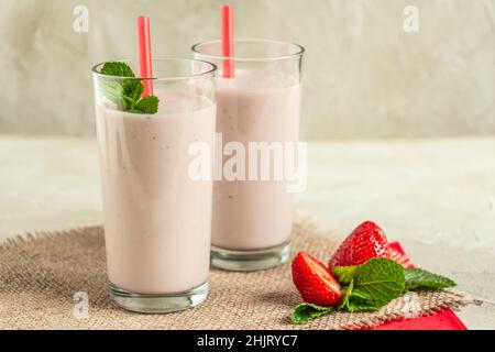 Köstlicher Milchshake mit Erdbeeren in hohen Gläsern Stockfoto