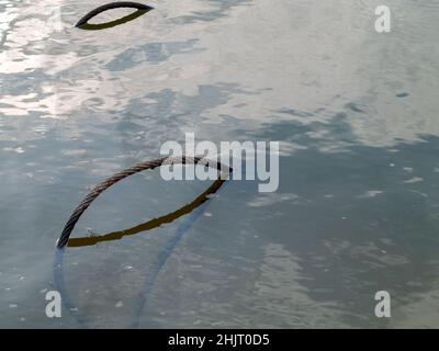 Im Sommer liegt im Fluss ein eisernes Kabel Stockfoto