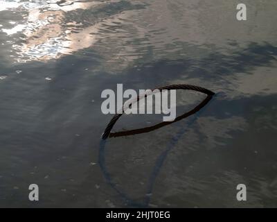 Im Sommer liegt im Fluss ein eisernes Kabel Stockfoto