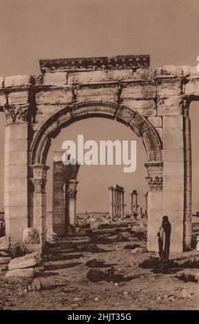 Carven Bogen und prächtige Säule zerbröckeln langsam durch die Jahrhunderte unter dem Wurf, der einst Zenobia's Palmyra war. Syrien. Levant (1923) Stockfoto