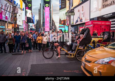 New York City, New York - 24. August 2019: Überfüllte Ecke mit Pediküre und Taxi am Times Square. Stockfoto