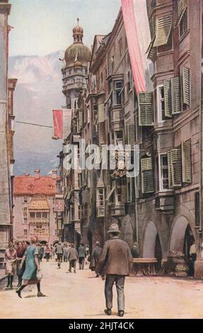 Gegenüber der Herzog-Friedrichstraße befindet sich das vergoldete Kupferdach eines Balkons namens Goldenes Dachl, der Teil eines alten Innsbrucker Schlosses ist. Österreich. Tirol (1923) Stockfoto