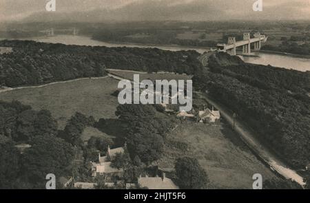 2 Brücken überqueren die Menai Strait zwischen dem Festland und Anglesey, Stephensons röhrenförmige Eisenbahnbrücke und Telfords Hängebrücke. Wales (1923) Stockfoto