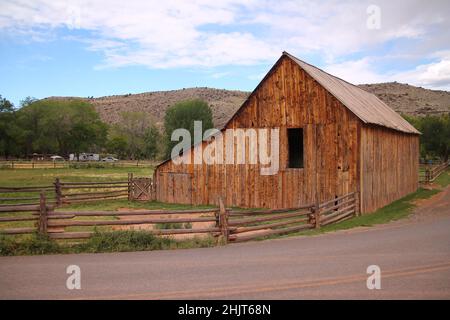 Das traditionelle Gifford Homestead Holzhaus mit der roten Schotterstraße in Fruita in Utah Stockfoto