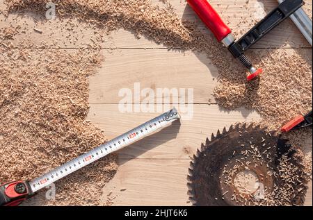 Schreinerei-Werkzeuge in Holzspangen auf Holzhintergrund aus Eichendielen mit expressiver Textur und natürlichem Muster Stockfoto