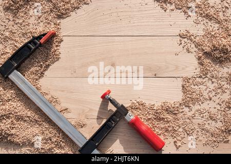 Schreinerei-Werkzeuge in Holzspangen auf Holzhintergrund aus Eichendielen mit expressiver Textur und natürlichem Muster Stockfoto