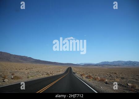 Gerade Straße in Richtung Bergkette am Horizont im Death Valley in Kalifornien Stockfoto