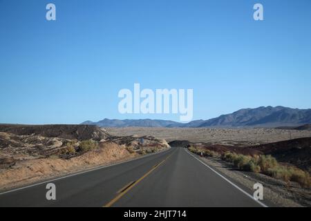 Death Valley Road quer durch die Wüste, die Berge in der Ferne. Kalifornien, USA Stockfoto