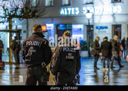 Cottbus, Deutschland. 31st Januar 2022. Polizeibeamte stehen auf dem Altmarkt, der sich langsam mit Teilnehmern einer registrierten Demonstration gegen die Corona-Politik füllt. Die vom brandenburgischen AfD-Fraktionsvorsitzenden Berndt registrierte Kundgebung wurde später zerstreut, weil Entfernungen und Masken nicht beobachtet wurden. Quelle: Frank Hammerschmidt/dpa/Alamy Live News Stockfoto