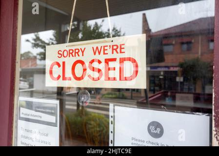 Ein „Sorry, wir sind geschlossen“-Schild in einem Ladenfenster, das auf eine Abschwäche oder einen Ausfall des Unternehmens oder eine Rezession oder Zwangsbeschränkungen in Australien hinzeigt Stockfoto