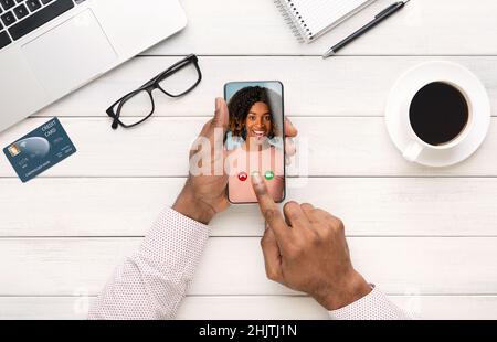 Konzept für Online-Meetings. Schwarzer männlicher Chef, der mit seiner Kollegin über Videoanruf diskutierte, Draufsicht Stockfoto