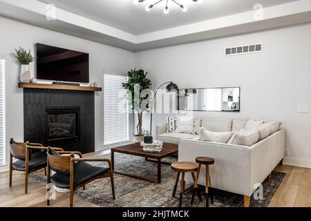 Moderne Küche und Esszimmer im mittleren Jahrhundert mit schwarzen Schränken, weißen Schränken, weißen Quarz- und Walnussakzenten Stockfoto