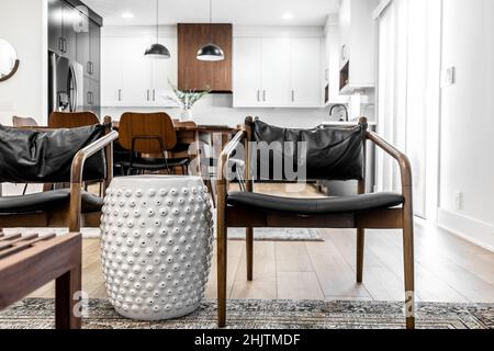 Moderne Küche und Esszimmer im mittleren Jahrhundert mit schwarzen Schränken, weißen Schränken, weißen Quarz- und Walnussakzenten Stockfoto