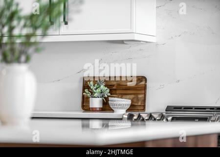 Moderne Küche und Esszimmer im mittleren Jahrhundert mit schwarzen Schränken, weißen Schränken, weißen Quarz- und Walnussakzenten Stockfoto