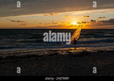 Sonnenuntergang am Strand der Ostsee mit Windsurfer Stockfoto