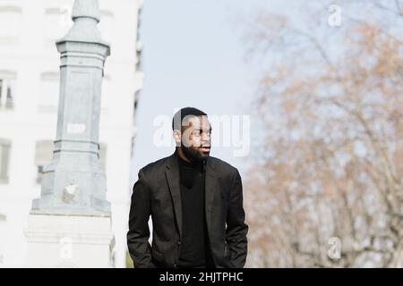 Junger Afro-Mann in frankreich, der im Winter draußen läuft Stockfoto
