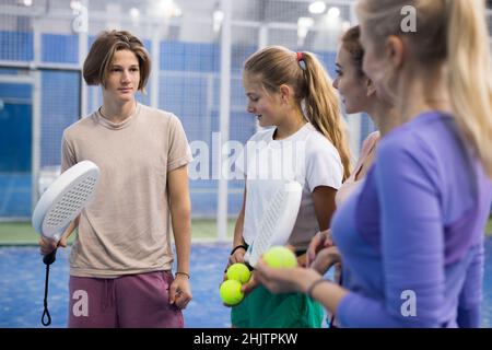 Vier Padel-Spieler stehen auf dem Platz und ruhen sich aus Stockfoto