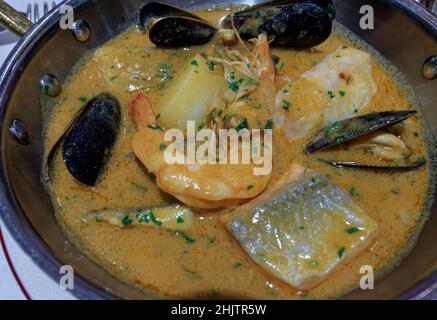 Fischeintopf, der in einer Pfanne oder Bouillabaisse serviert wird, ein traditionelles, köstliches Suppengericht mit Meeresfrüchten und Garnelen, Muscheln und frischen Fischstücken Stockfoto