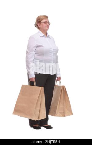 Bild einer lächelnden Frau, die auf die Kamera schaut und mit ihren Einkaufstaschen steht Stockfoto