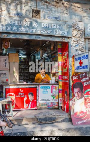 Ein typischer kleiner Kiosk am Straßenrand und ein Ladenbesitzer am Straßenrand in Varanasi, einer Stadt am Fluss Ganges in Uttar Pradesh, Nordindien Stockfoto