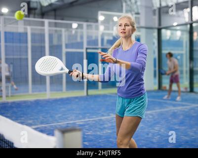 Frau spielt Padel auf dem Hof Stockfoto