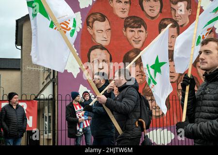 Derry, Großbritannien. 30th Januar 2022. Die Demonstranten marschieren an einem Wandgemälde vorbei, auf dem die Opfer der Schüsse auf den Blutigen Sonntag im Bezirk Bogside von Derry dargestellt sind.Hunderte von Menschen versammelten sich am Sonntag in Derry, um den Verwandten derer, die vor fünfzig Jahren beim Massaker von Bloody Sunday getötet wurden, ihre Achtung zu erweisen. Am 30th. Januar 1972 wurden Bürgerrechtler, die in Derry marschierten, von britischen Fallschirmjägern angeschossen, was zum Tod von 14 Menschen und zu den Verletzungen von Dutzenden weiteren führte. Kredit: SOPA Images Limited/Alamy Live Nachrichten Stockfoto