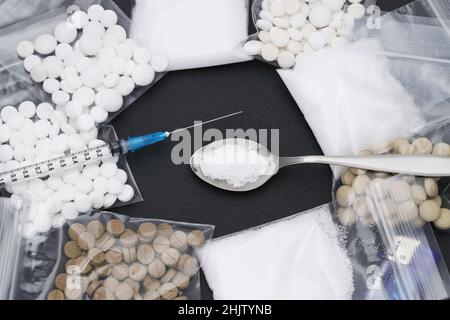 Gekochte Heroindrogen und Injektionsspritze auf schwarzem Hintergrund Stockfoto