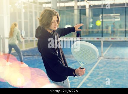 Teenager spielt Paddle Tennis auf dem Padel Court Stockfoto
