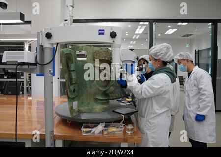 (220201) -- CHENGDU, 1. Februar 2022 (Xinhua) -- das Aktenfoto zeigt, wie Mitarbeiter die Bronzemaske reparieren, die auf der Sanxingdui-Ruinenstätte in der südwestlichen Provinz Sichuan entdeckt wurde. Die größte Bronzemaske, die aus der legendären Sanxingdui-Ruinenstätte in Sichuan ausgegraben wurde, traf die Öffentlichkeit bei der TV-Gala des Spring Festival am Montag.die Maske ist 131 cm breit, 71 cm hoch und 66 cm tief, Und wiegt 65,5 kg, sagte Tang Fei, Leiter des Forschungsinstituts für kulturelle Reliquien und Archäologie der Provinz Sichuan. (Institut für Kulturelle Reliquien und Archäologie der Provinz Sichuan & Sanxingdui Museum/Handout via Xi Stockfoto