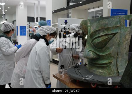 (220201) -- CHENGDU, 1. Februar 2022 (Xinhua) -- das Aktenfoto zeigt, wie Mitarbeiter die Bronzemaske reparieren, die auf der Sanxingdui-Ruinenstätte in der südwestlichen Provinz Sichuan entdeckt wurde. Die größte Bronzemaske, die aus der legendären Sanxingdui-Ruinenstätte in Sichuan ausgegraben wurde, traf die Öffentlichkeit bei der TV-Gala des Spring Festival am Montag.die Maske ist 131 cm breit, 71 cm hoch und 66 cm tief, Und wiegt 65,5 kg, sagte Tang Fei, Leiter des Forschungsinstituts für kulturelle Reliquien und Archäologie der Provinz Sichuan. (National Cultural Heritage Administration/Handout via Xinhua) Stockfoto