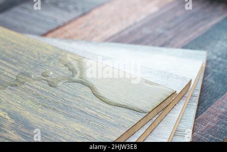 Laminat und Wasser. Wasserdichtes Laminat. Holzböden sind unempfindlich gegen Feuchtigkeit. Bodenbeläge schützen vor Wasser. Eine Pfütze auf dem Boden. Stockfoto