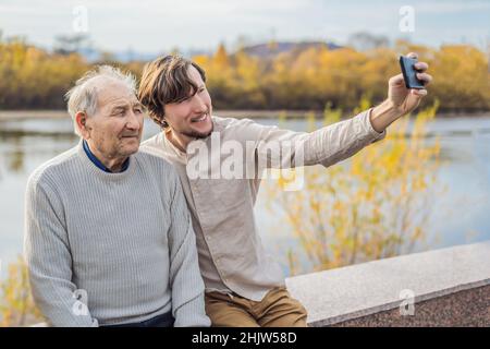 Ein Mann macht ein Selfie mit einem älteren Mann Stockfoto