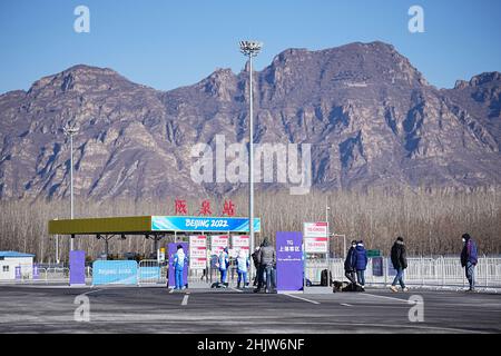 Yanqing, China. 01st. Februar 2022. Freiwillige und Journalisten warten an einer Bushaltestelle. Die Olympischen Winterspiele in Peking finden vom 04. Bis 20.02.2022. September unter strengen Corona-Bedingungen statt. Quelle: Michael Kappeler/dpa/Alamy Live News Stockfoto