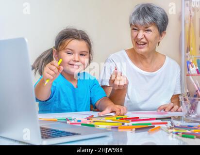 Großmutter und Kind lernen online miteinander zu zeichnen Stockfoto